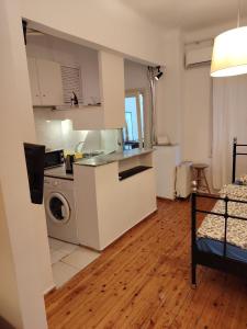 White Tower Cozy Studio OYR1 في سلانيك: مطبخ مع غسالة ومجفف في الغرفة