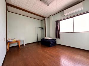a room with a large window and a bed in it at cozy guesthouse in Osaka