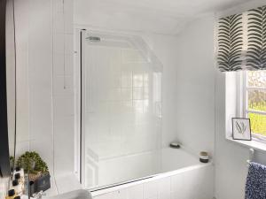 a white bathroom with a shower and a sink at Shearwaters in Saint Mawes