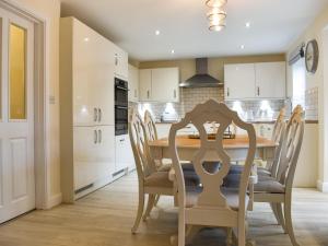 Song Bird Holiday Home في ويتبي: مطبخ مع طاولة وكراسي خشبية +15 صورة