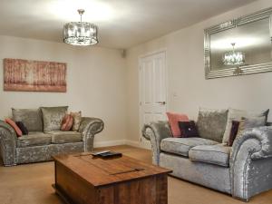 Song Bird Holiday Home في ويتبي: غرفة معيشة مع أريكتين وطاولة قهوة