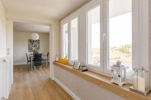a living room with windows and a dining room with a table at El mirador de Teresa in Arróniz