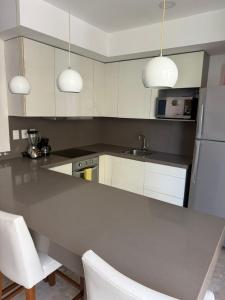 AULIFER Luxury Apartments في بلايا ديل كارمن: مطبخ مع طاولة و كرسيين بيض