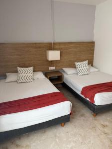 AULIFER Luxury Apartments في بلايا ديل كارمن: سريران في غرفة فندق مع