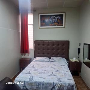 Un dormitorio con una cama y un cuadro en la pared. en Anciejo inn ll, en Lima