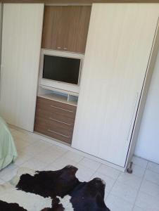ItaquiQuarto para hospedagem的电视前的地板上放着一只狗