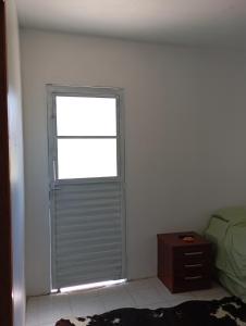 ItaquiQuarto para hospedagem的卧室设有窗户、一张床和一张桌子