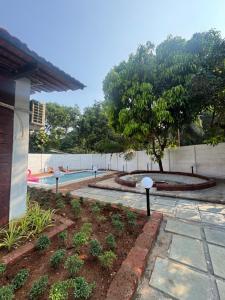 a backyard with a swimming pool and a garden at NOSSA GOA VILLA in MUMBAI GORAI in Mumbai