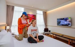 a woman cutting a girls hair in a hotel room at Lub d Bangkok Chinatown - Steps from Sam Yod MRT Station in Bangkok