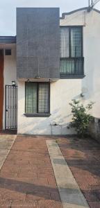 a white building with two windows and a door at Casa entera, elegante, moderna in Guadalajara