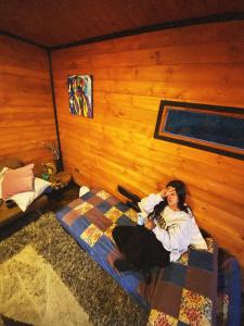 een vrouw zittend op een bed in een kamer bij Casa Jaguar Neusa in Tausa Viejo