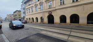 Centrally located cozy apartment في كراكوف: سيارة متوقفة في شارع مجاور لمبنى