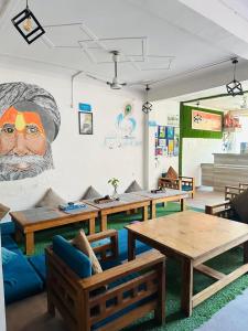 a room with tables and a large painting on the wall at Hop Inn Hostels Rishikesh in Tapovan