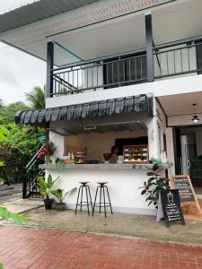 a restaurant with two stools in front of a building at Mook tawan Beach house in Ko Mook