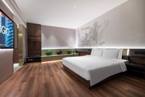 呼和浩特呼和浩特东站CiTiGO欢阁酒店的卧室里有一张白色的大床和一台电视