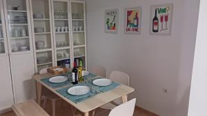 a dining room table with two white plates on it at casa andaluza 109 in Novo Sancti Petri