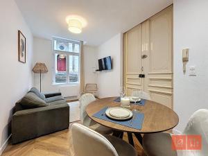a living room with a table and a couch at Le Parvis - Vieille ville - proche plage et port in Boulogne-sur-Mer