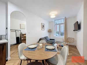 a living room with a table and chairs in a room at Le Parvis - Vieille ville - proche plage et port in Boulogne-sur-Mer +2 photos