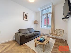 a living room with a couch and a table at Le Parvis - Vieille ville - proche plage et port in Boulogne-sur-Mer