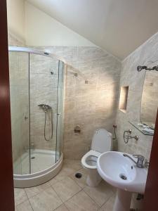 un bagno con doccia, WC e lavandino di Sunrise Hotel ad Adjud