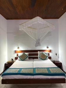 a bedroom with a bed with a mosquito net at Chaya Villa Guest House in Beruwala