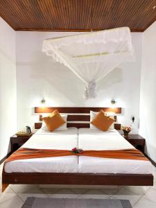a bedroom with a large bed with a canopy at Chaya Villa Guest House in Beruwala