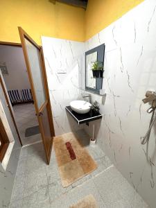 a bathroom with a sink and a mirror at Chaya Villa Guest House in Beruwala