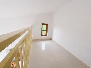 a staircase in a white room with a window at Shlok Villa in Bāmangaon