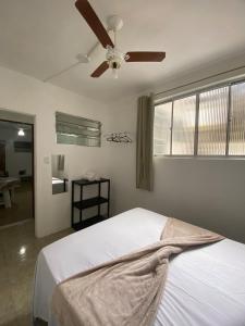 a bedroom with a bed with a ceiling fan at Ao lado do Hospital Calixto apartamento térreo in Itabuna