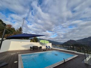 a swimming pool with an umbrella and a table and chairs at Gerescasadapraia in Geres
