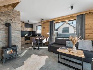 Una sala de estar con un sofá y una chimenea. en Tatra Village, en PyzÃ³wka 24 fotos más