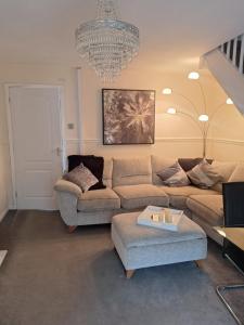 ein Wohnzimmer mit einer Couch und einem Kronleuchter in der Unterkunft Gorgeous Sandpiper Mews in Worcester
