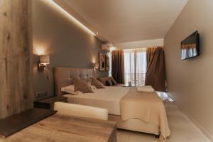 a bedroom with a large bed and a window at AKRON Luxury Holidays in Ancient Epidauros