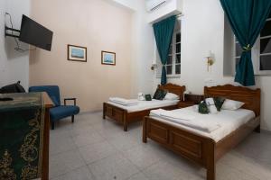 a hotel room with two beds and a tv at Archontiko Hotel in Kalymnos