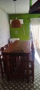 un tavolo e sedie in legno in una stanza con parete verde di AZUL Casa De Campo a Esquina