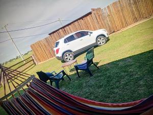 un'auto parcheggiata in un cortile con sedie e amaca di AZUL Casa De Campo a Esquina 1 altra foto
