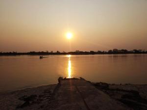 una persona in piedi sulla riva di un fiume al tramonto di AZUL Casa De Campo a Esquina