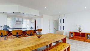 a kitchen and dining room with a wooden table and chairs at Guernsey Home in Port Shepstone +28 photos