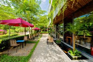 a patio with tables and chairs and an umbrella at Gia Huy Riverside Hotel Hoi An in Hoi An +82 photos