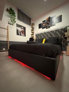 a black bed with a red light in a room at La Sensuelle Parenthèse in Sète