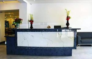 um lobby com um balcão de mármore com flores em Krushnai Resort em Kharakvasla