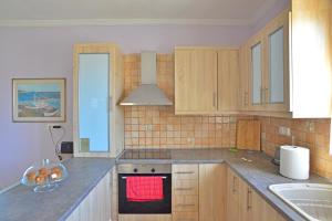 a kitchen with wooden cabinets and a red towel on the oven at Tzitzi Pistachio Villa in Khlóï