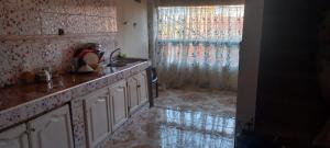 a kitchen with a sink and a counter top at Ashila hawmat ginawa in Asilah