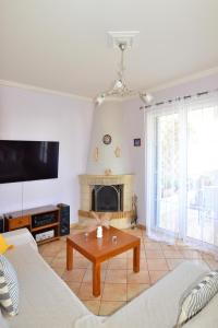 a living room with a table and a fireplace at Tzitzi Pistachio Villa in Khlóï