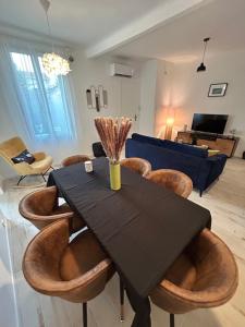 a dining room with a black table and chairs at Jolie maison de vacances proche du centre et de la mer in Saint-Raphaël