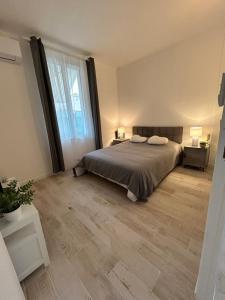 a bedroom with a bed and a large window at Jolie maison de vacances proche du centre et de la mer in Saint-Raphaël