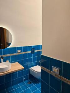 ein blau gefliestes Badezimmer mit Toilette und Waschbecken in der Unterkunft Domus Gazzara -Napoli Centro Storico in Neapel