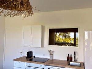 a kitchen with white cabinets and a sink and a window at Always Sun ,1 bdr up to 4 guests in Baie Nettle