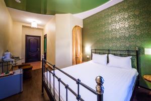 1 dormitorio con cama y pared verde en Hotel Khalif, en Tomsk