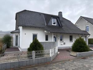 een wit huis met een zwart dak bij Ferienwohnung Ruhrtal in Bestwig